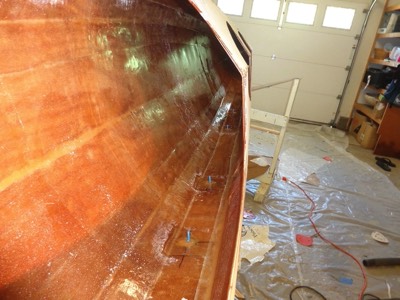  6/16/19 - The boat is tilted on its starboard side and the deck/hull seam is filled with epoxy and fiberglassed. 