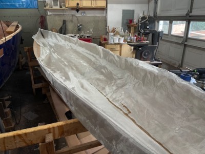  2/10/21 - Fiberglass cloth is laid on the interior of the hull. 