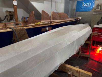  3/11/21 - Fiberglass cloth is laid on the hull. 