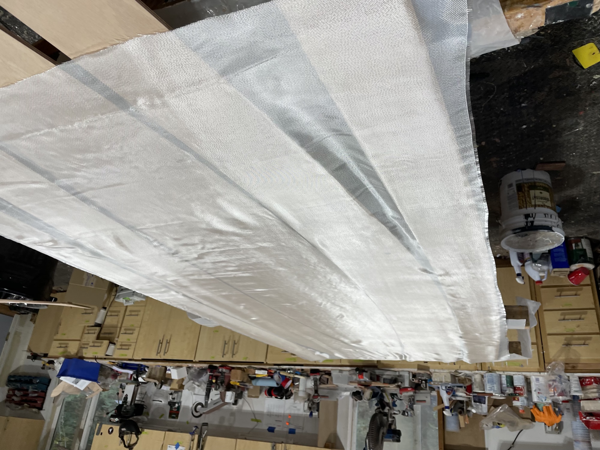  10/13/22 - Fiberglass is laid on hull panels. 