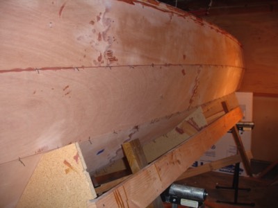  The boat is lowered and tilted so the wires can be clipped and the seams glued. 